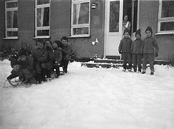 Uniformsklædte børn, der fra bygningen kunne kælke ned ad en stor bakke langt ud i haven. Billedet er fra 1950'erne