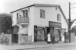 Snekkersten Specialforretning med købmandsparret Anders og Petrea i døråbningen omkring 1930.
