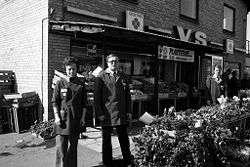 Købmand Per Arevad foran sin forretning 24/4 1974. Kvinden ved hans side menes at være hans hustru. Foto: Anne-Sofie Rubæk